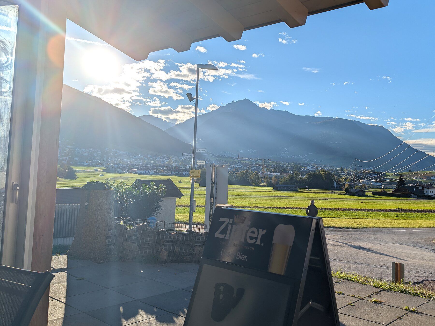 Blick von der überdachten Terrasse auf die Berge bei tiefstehender Sonne